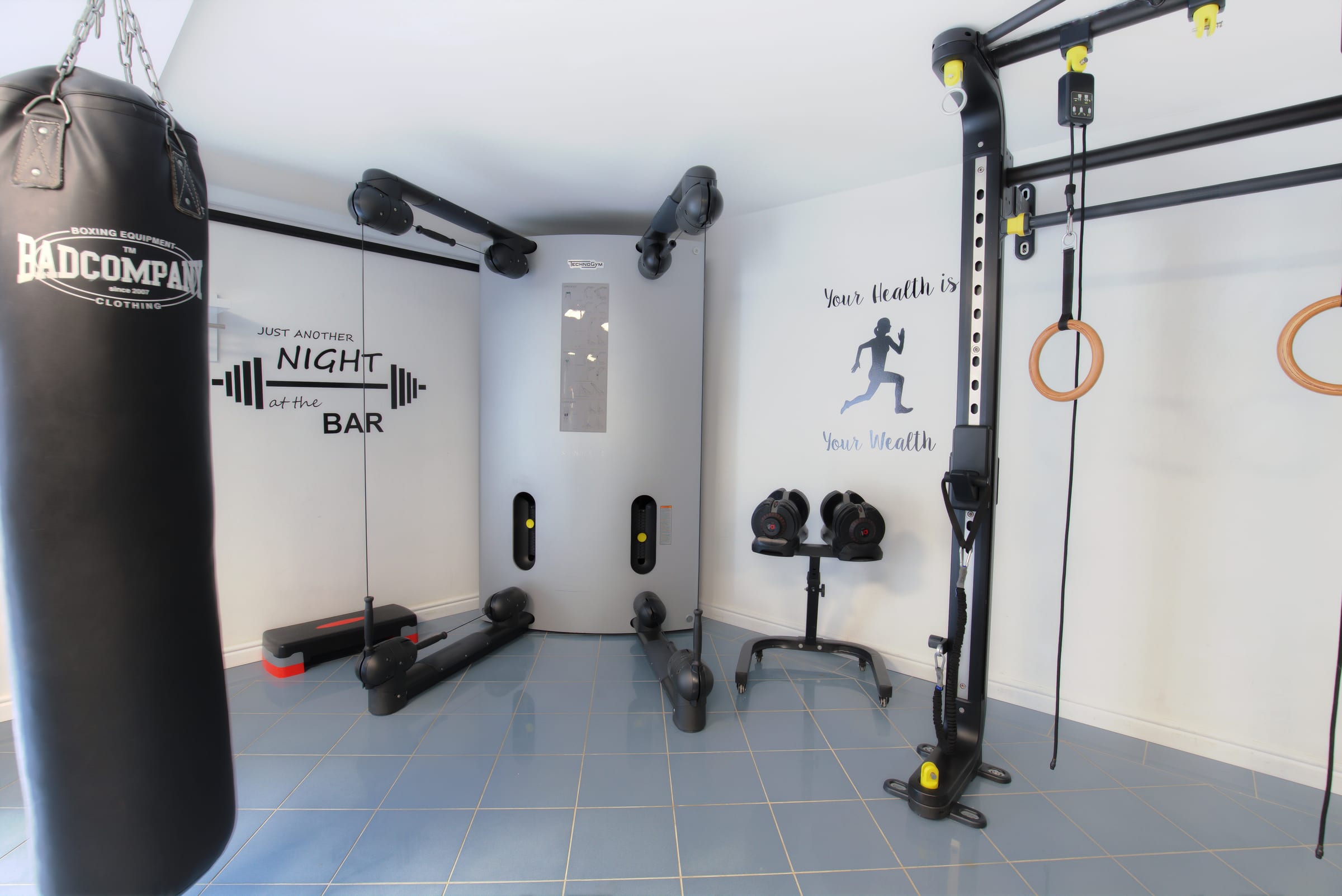 Kraftbereich mit Trainingsstation, freien Gewichten und Boxsack