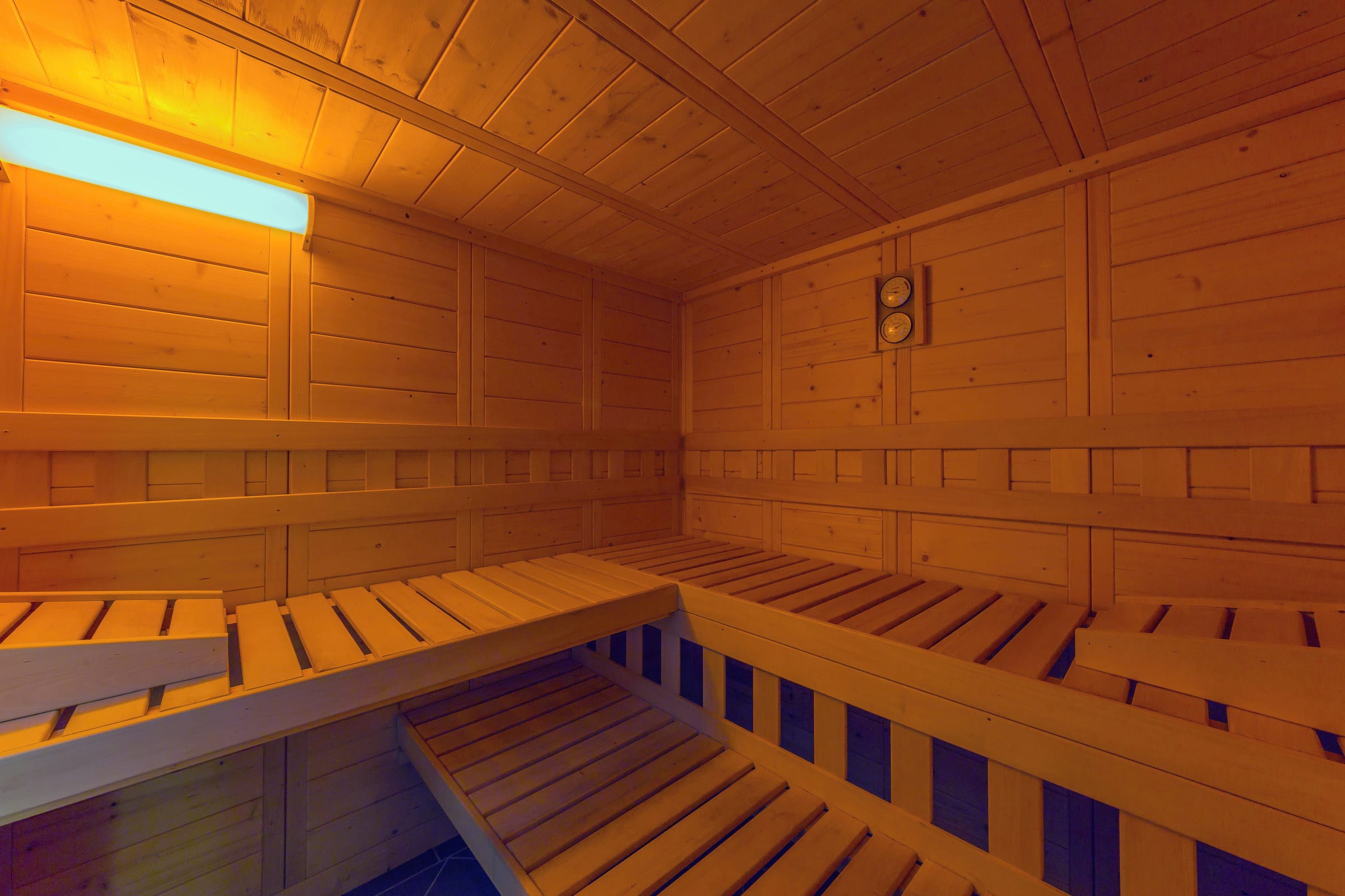Bio-Sauna aus hellem Holz mit umlaufenden Liegebänken